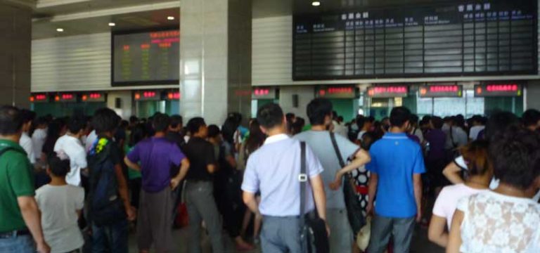 People standing in line to buy bus tickets in China